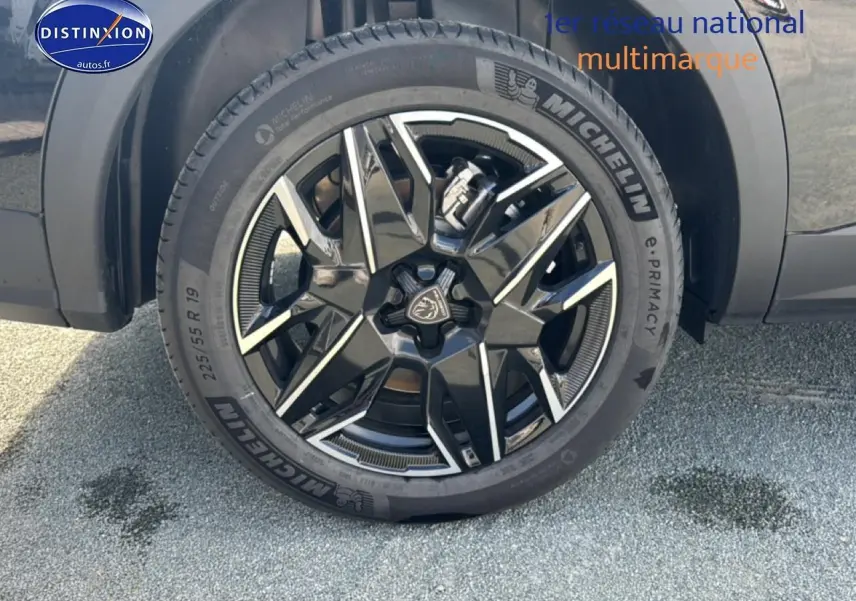 Gros plan sur la jante alu noire et argentée Michelin d’un Peugeot 5008 Hybrid 145 allure e-dcs6 noir, roue avant droite.
