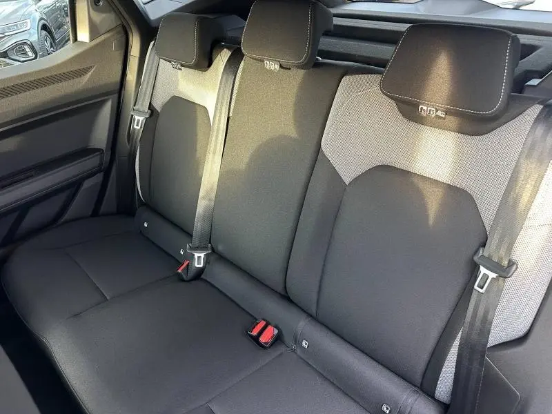 Vue intérieure sur la banquette arrière noire et grise du Dacia Duster 2025, avec ceintures de sécurité et appuie-têtes visibles.