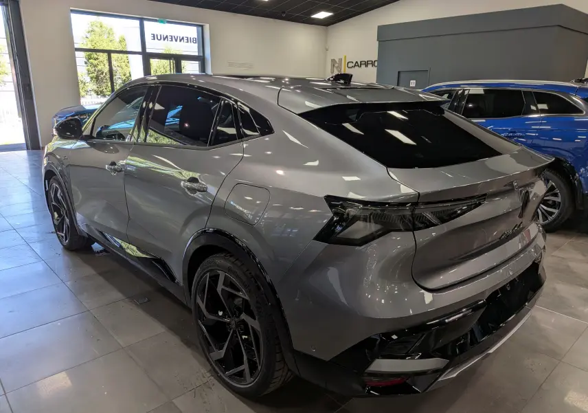 Vue 3/4 arrière droite d’un Renault Rafale gris schiste avec jantes noires et vitres teintées en showroom.