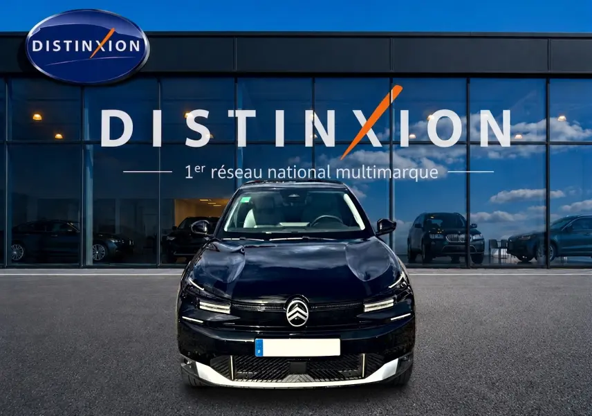 Vue de face d'une Citroën C4 X noire 2025 stationnée devant une vitrine avec logo Distinxion.