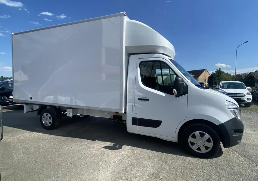 Vue de profil côté droit d'un utilitaire blanc Nissan Interstar Acenta 2022 avec capucine sur parking en extérieur.