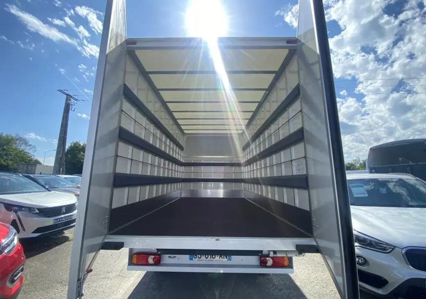 Vue arrière du Nissan Interstar blanc 2022 avec portes ouvertes montrant l'espace de chargement grand volume vide.