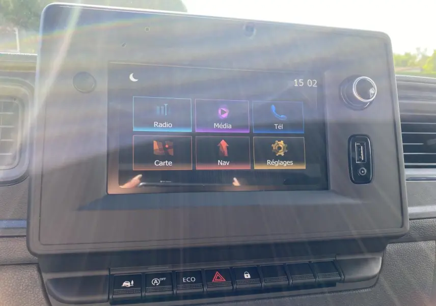 Écran tactile du système NissanConnect avec menu principal, port USB et commandes intégrées, intérieur du Nissan Interstar blanc.