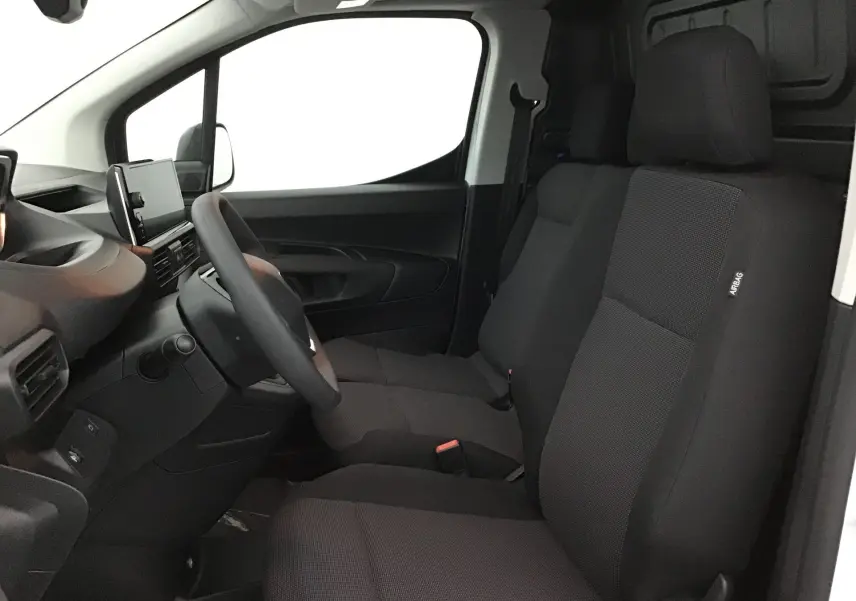 Intérieur avant droit du Peugeot Partner blanc, montrant les sièges noirs et le tableau de bord moderne avec écran tactile.