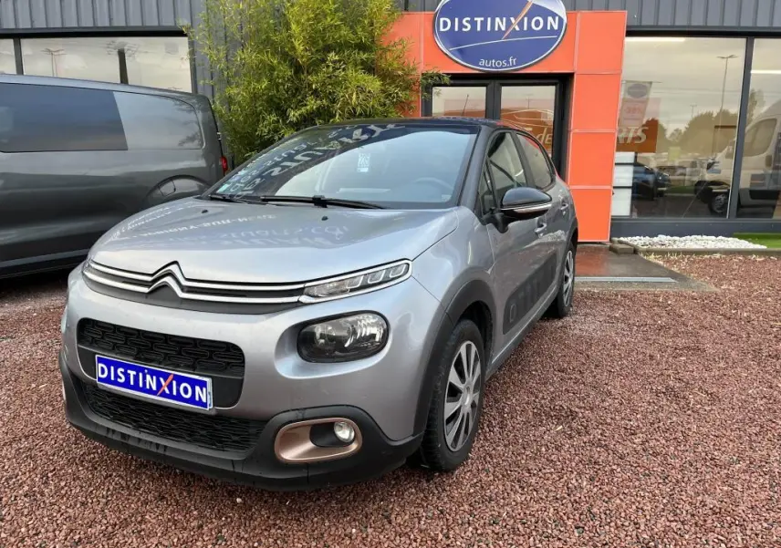 Citroën C3 gris foncé vue 3/4 avant droit avec toit noir et détails noirs autour des phares et rétroviseurs.