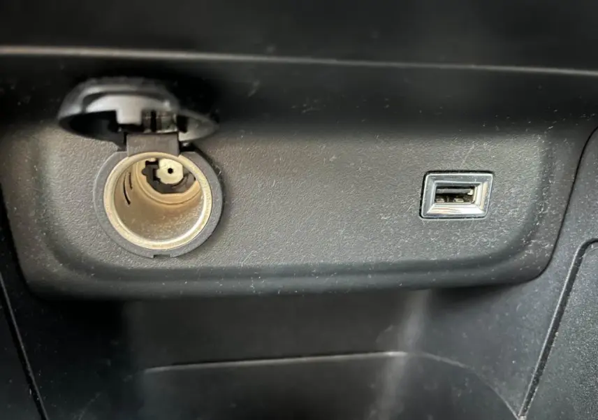 Prise allume-cigare et port USB intégrés dans la console centrale noire d'une Citroën C3 2019 gris foncé Origins.