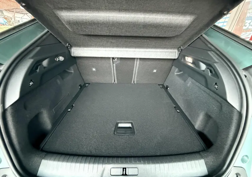 Coffre ouvert du Peugeot 3008 Hybrid 2025 en bleu Ingaro Metal, montrant un espace de chargement propre et bien agencé.