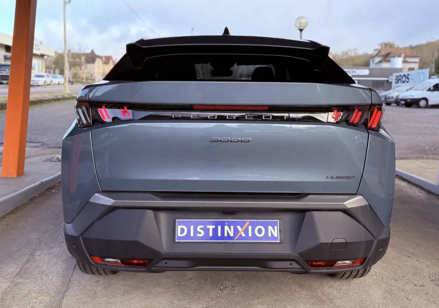 Vue arrière d'un Peugeot 3008 Hybrid 2025 en bleu Ingaro Métal avec feux arrière à griffes rouges et logo distinctif.
