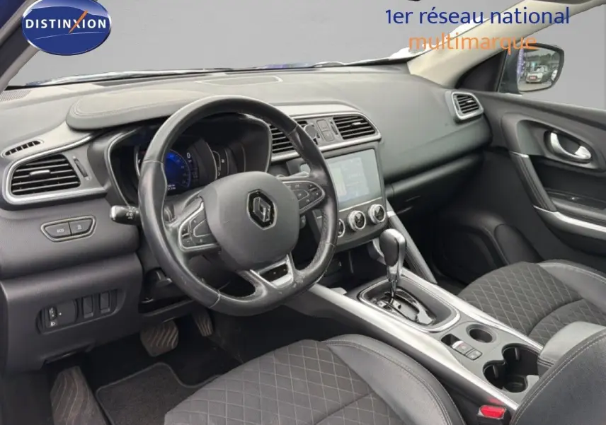 Vue intérieure côté conducteur du Renault Kadjar 2021, tableau de bord noir avec volant multifonction et console centrale moderne.
