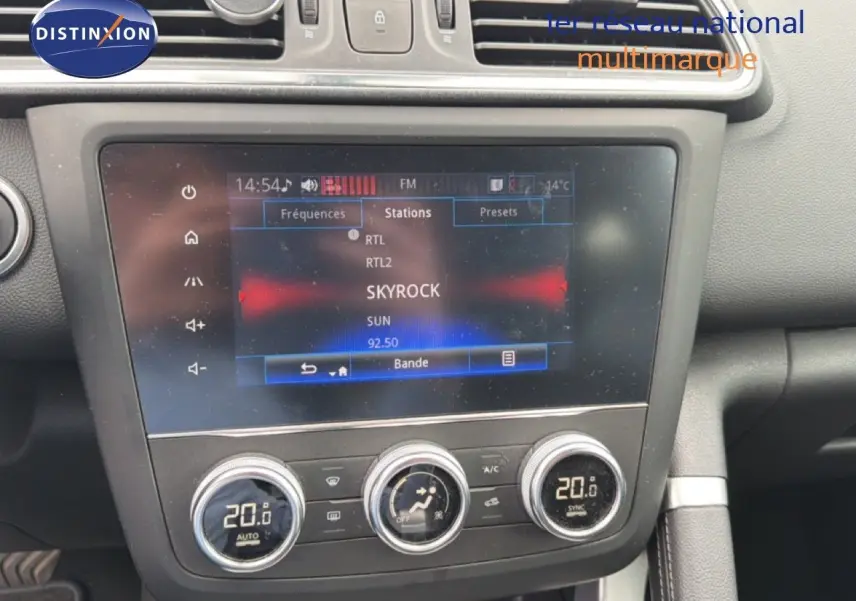 Vue rapprochée de la console centrale du Renault Kadjar 2021, écran tactile affichant la radio et commandes de climatisation digitales.
