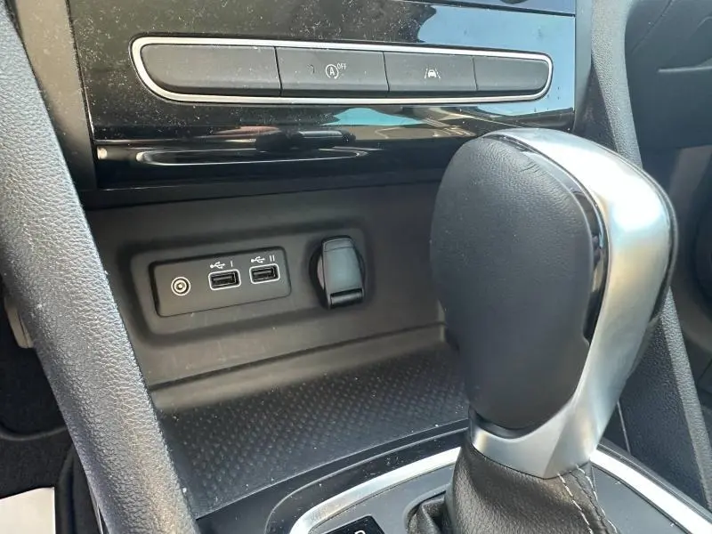 Gros plan sur le levier de vitesse automatique et les ports USB dans l’habitacle noir de la Renault Mégane Break gris Titanium 2024.