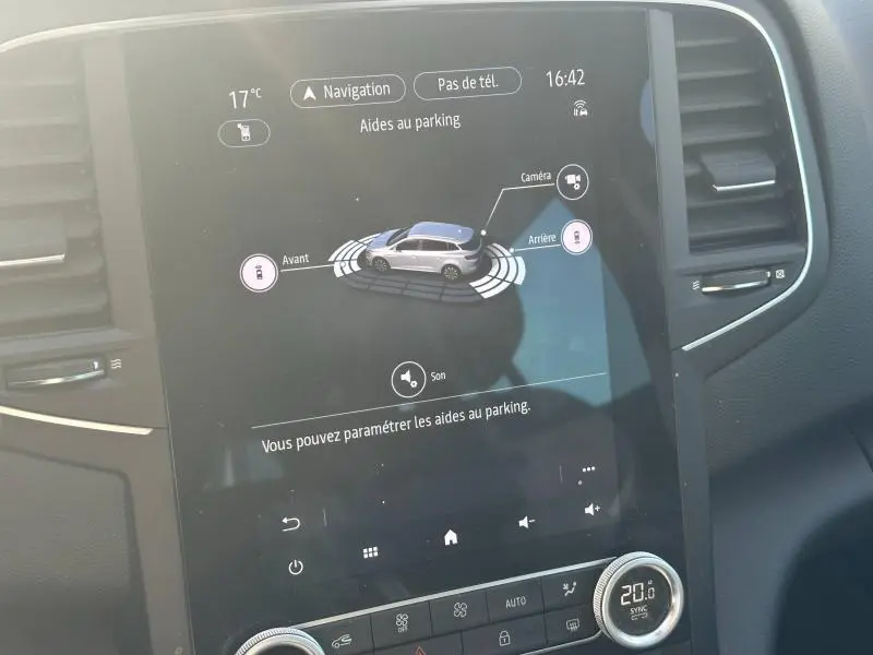 Écran tactile intérieur montrant l'aide au parking du Renault Mégane Break gris titanium, vue de face du tableau de bord.