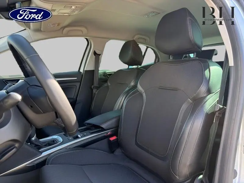 Vue intérieure côté conducteur de la Renault Mégane 1.5 Blue dCi gris Highland, sièges mixtes similicuir/tissu noirs et console centrale.