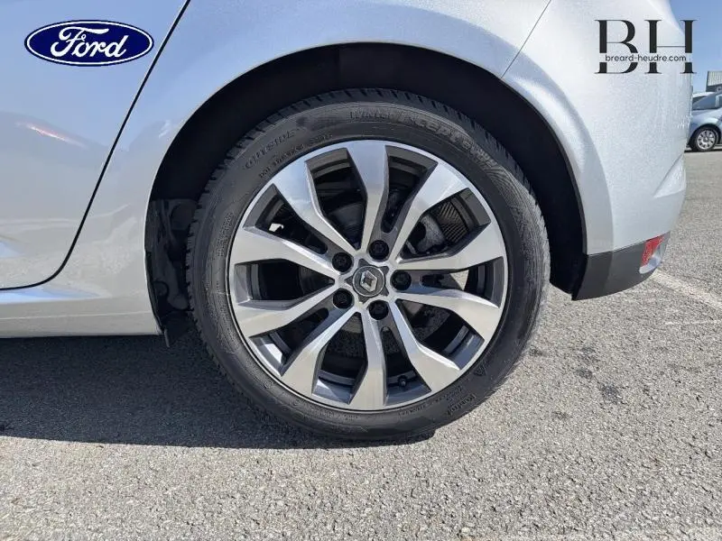 Gros plan sur la roue arrière droite avec jante alu bicolore de la Renault Mégane gris Highland 2023.