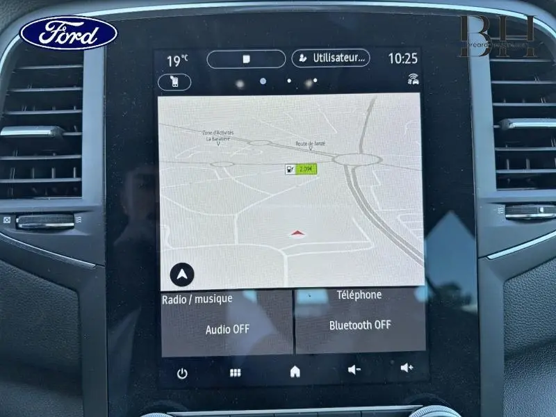 Écran tactile central avec navigation GPS allumée dans une Renault Mégane gris Highland, vue de face.