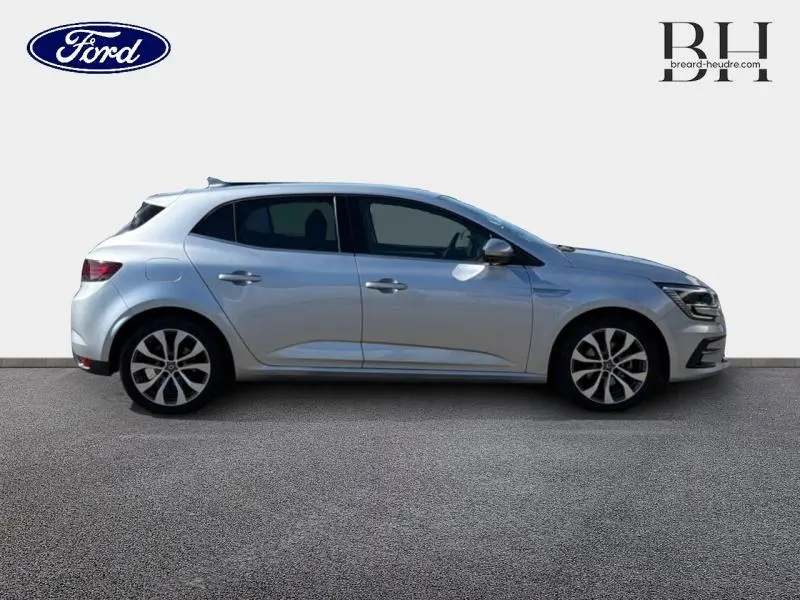 Profil droit d'une Renault Mégane gris Highland 2023 avec jantes alliage et vitres teintées.