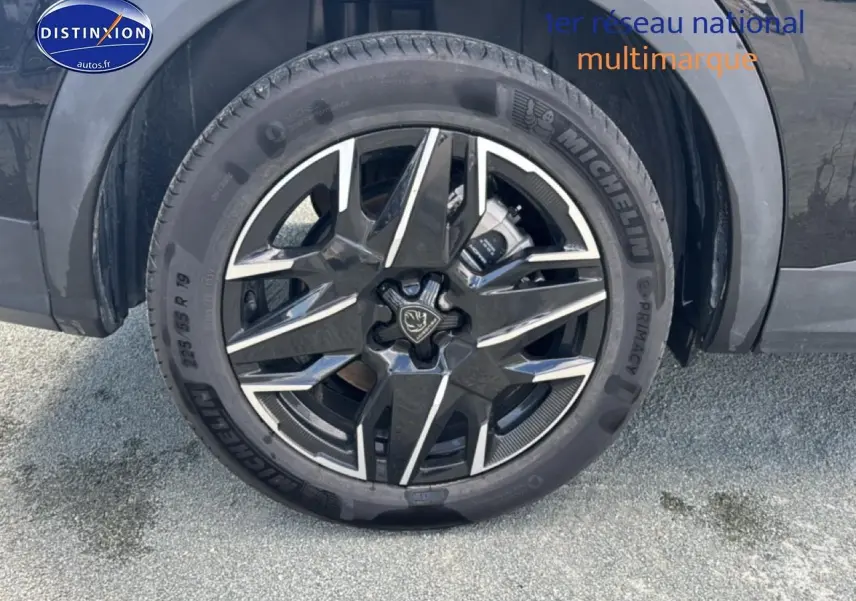 Gros plan sur la jante alu noire et argentée d’un Peugeot 5008 Hybrid 145 allure e-dcs6 noir, côté arrière droit.