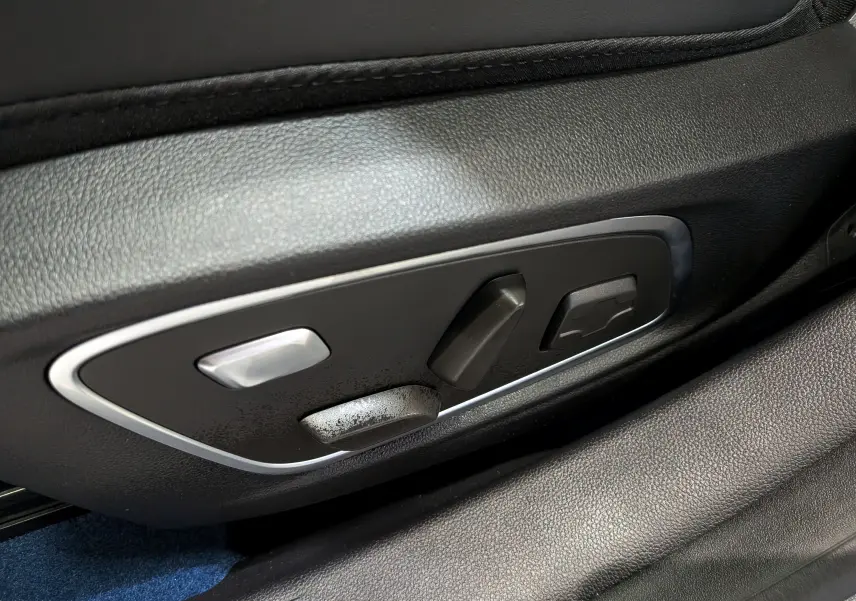Gros plan sur les commandes de réglage électrique du siège en cuir noir du Renault Rafale hyper hybrid gris Schiste.