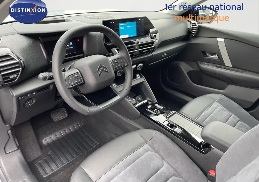 Intérieur moderne de Citroën C4 2024, vue côté conducteur, sièges gris cuir et alcantara, tableau de bord avec écran tactile.