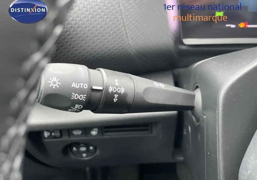 Gros plan sur la commande des phares et clignotants à gauche du volant d'une Citroën C4 blanche métal 2024.