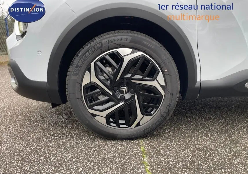 Gros plan sur la roue avant gauche de la Citroën C4 blanche métal avec jante alliage au design moderne.