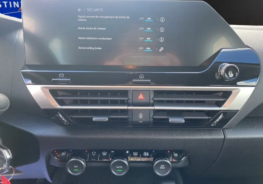 Détail du tableau de bord de la Citroën C4 hybride 2025 montrant l'écran tactile et les commandes de climatisation.