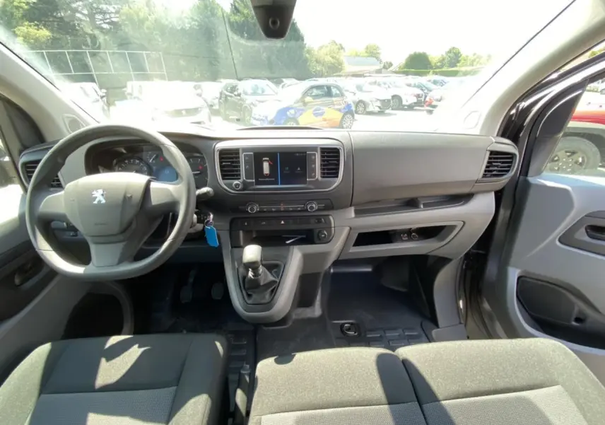 Vue intérieure avant du Peugeot Expert Fourgon gris platinium, montrant le tableau de bord et la banquette Moduwork.