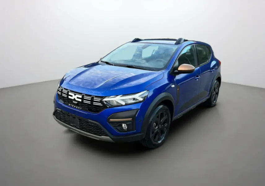 Vue 3/4 avant d'une Dacia Sandero Stepway 2024 bleu iron avec coques de rétroviseurs bronze et jantes noires.