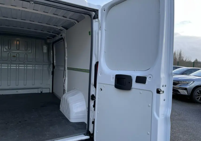 Vue arrière ouverte du fourgon blanc Opel Movano 2024, montrant l’intérieur vide et plancher noir.