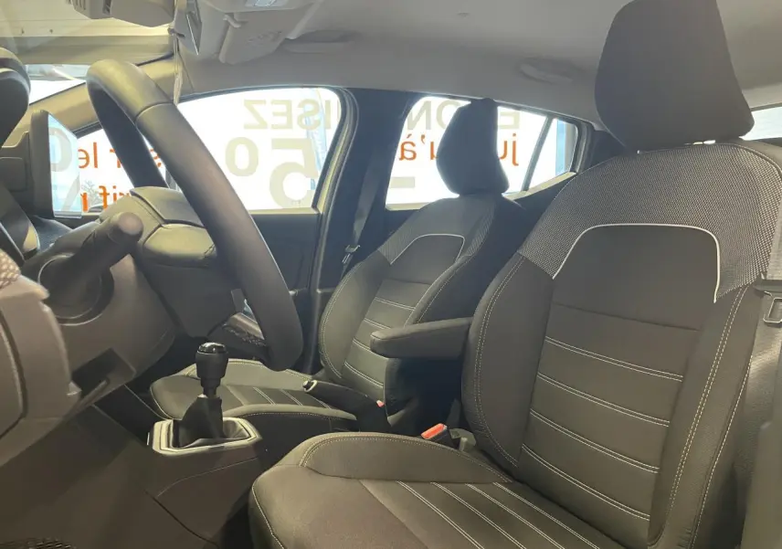 Vue intérieure de profil droit du Dacia Sandero TCe 90 Stepway Expression 2025, montrant les sièges noirs et la boîte manuelle.
