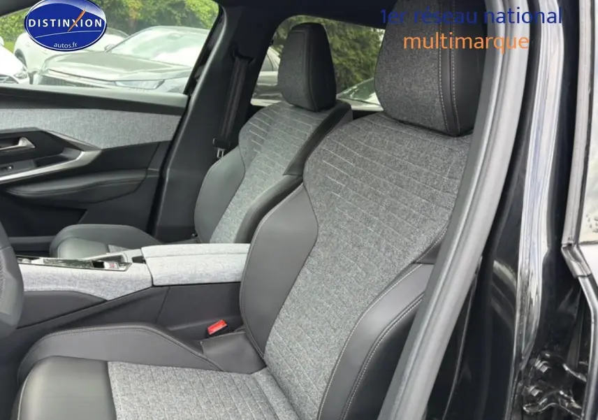 Vue intérieure côté droit du Peugeot 5008 noir 2025, mettant en valeur les sièges en tissu gris et cuir noir avec accoudoir central.