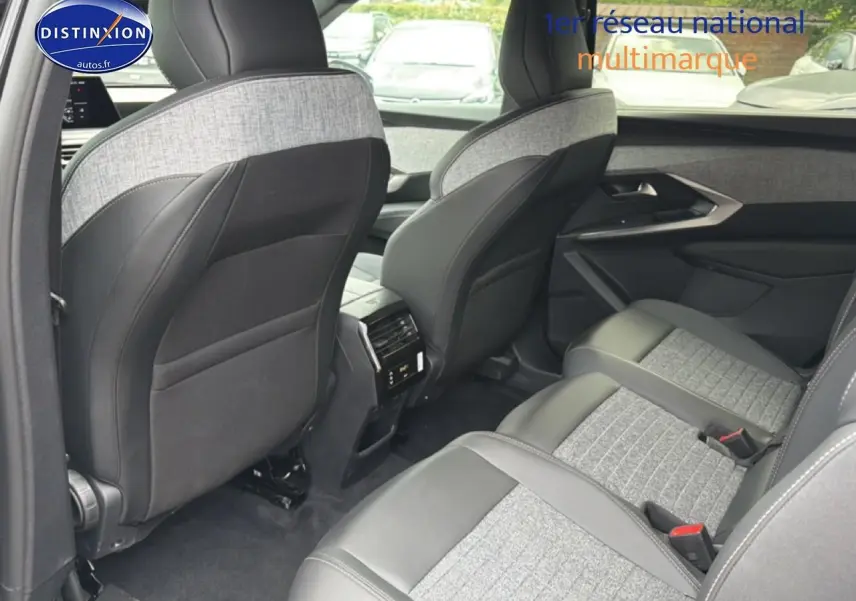 Vue intérieure arrière droite du Peugeot 5008 Hybrid 145 allure 2025 avec sièges en tissu gris et cuir noir.