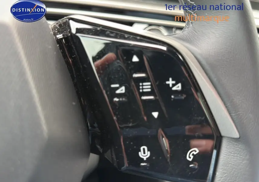 Gros plan sur les commandes vocales et audio au volant cuir du Peugeot 5008 noir, version Hybrid 145 allure e-dcs6.