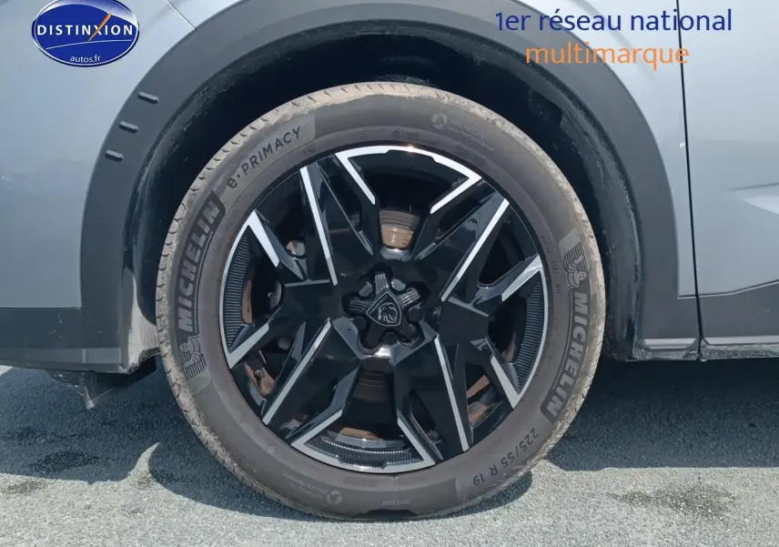 Gros plan sur la roue avant droite du Peugeot 5008 gris artense, mettant en valeur la jante alu noire et argentée.