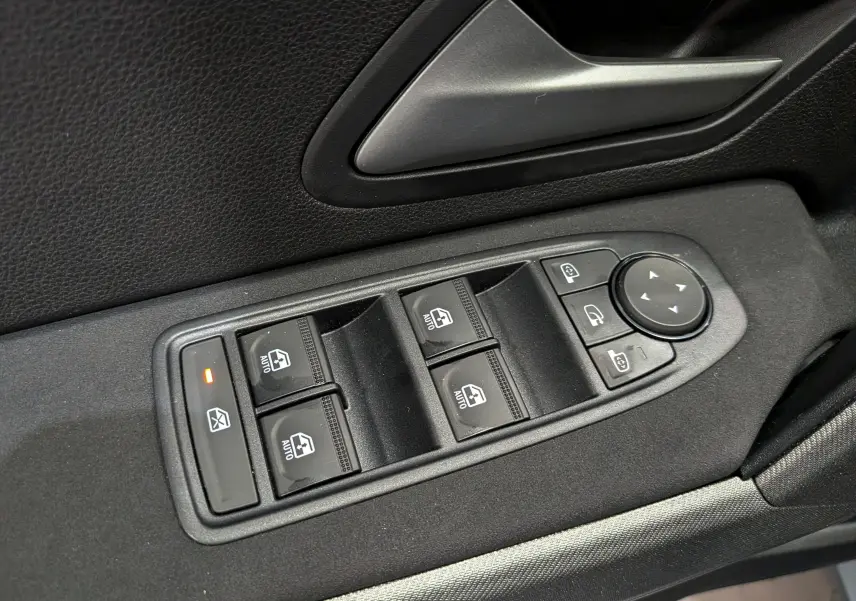 Gros plan sur les commandes de lève-vitres et rétroviseurs côté conducteur du Dacia Bigster noir nacré 2026.