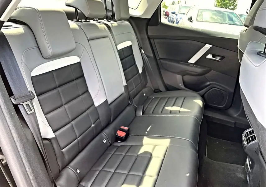 Vue intérieure montrant la banquette arrière bicolore noire et grise du Citroën C4 X 2025 côté droit.