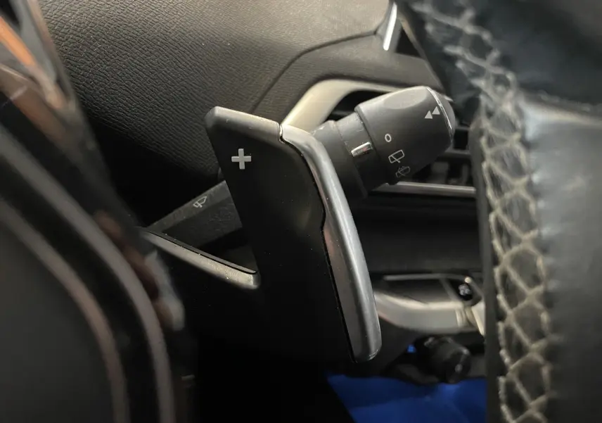 Gros plan sur la palette de changement de vitesse "+" côté droit du volant du Peugeot 5008 blanc nacré 2019.