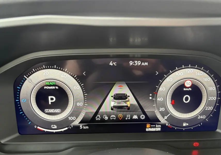 Tableau de bord numérique du Nissan Qashqai hybride, affichage central avec vitesse et indicateurs, ambiance moderne.