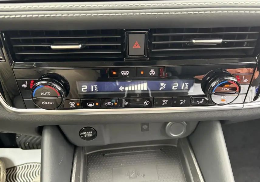 Vue rapprochée de la console centrale du Nissan Qashqai 2025, avec commandes climatisation automatique et bouton start/stop.