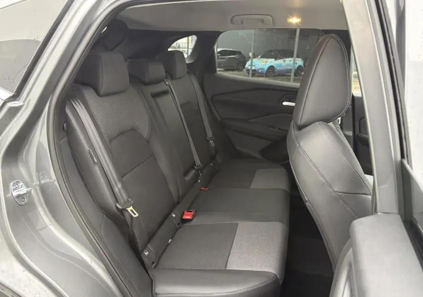 Vue côté gauche sur la banquette arrière mixte tissu et TEP noire du Nissan Qashqai III gris foncé, avec ceinture de sécurité visible.