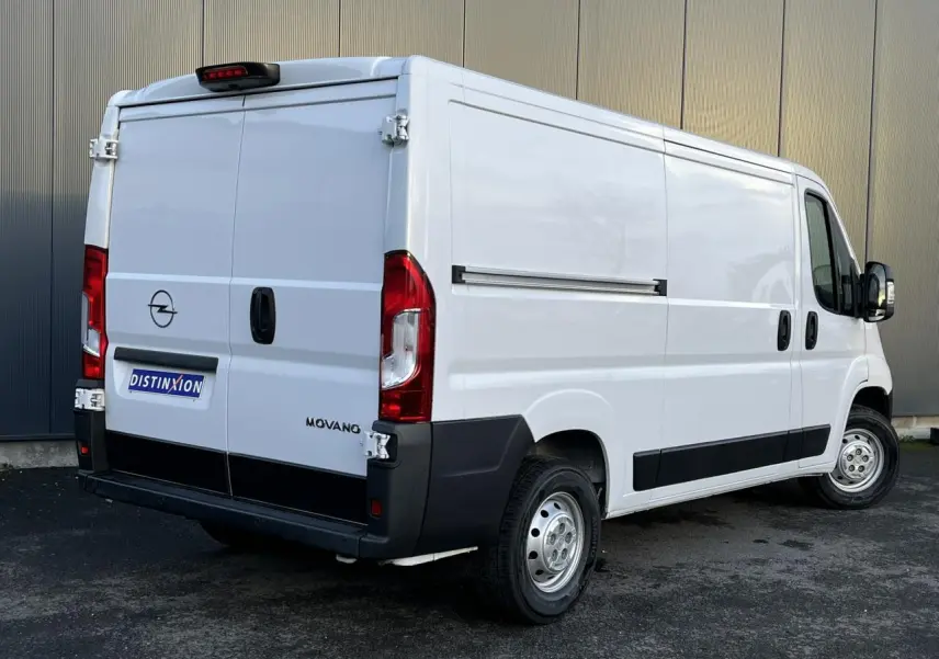 Vue 3/4 arrière droite d'un fourgon Opel Movano blanc avec portes arrière battantes et protections noires sur bas de caisse.