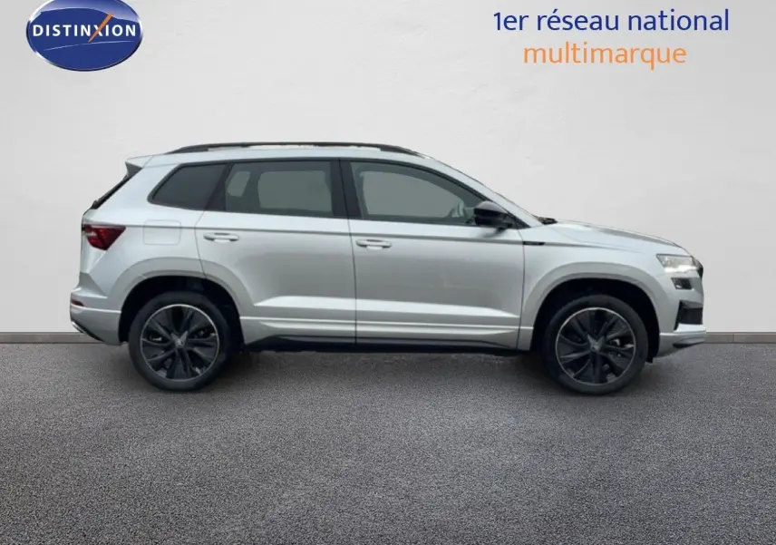 Profil droit d'un Skoda Karoq 2025 gris argent métal, finition Sportline avec jantes noires et toit ouvrant.