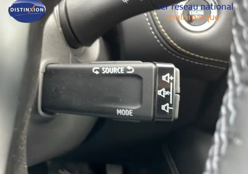 Détail de la commande audio au volant du Renault Symbioz 2025, avec bouton source et mode, sur fond intérieur noir.