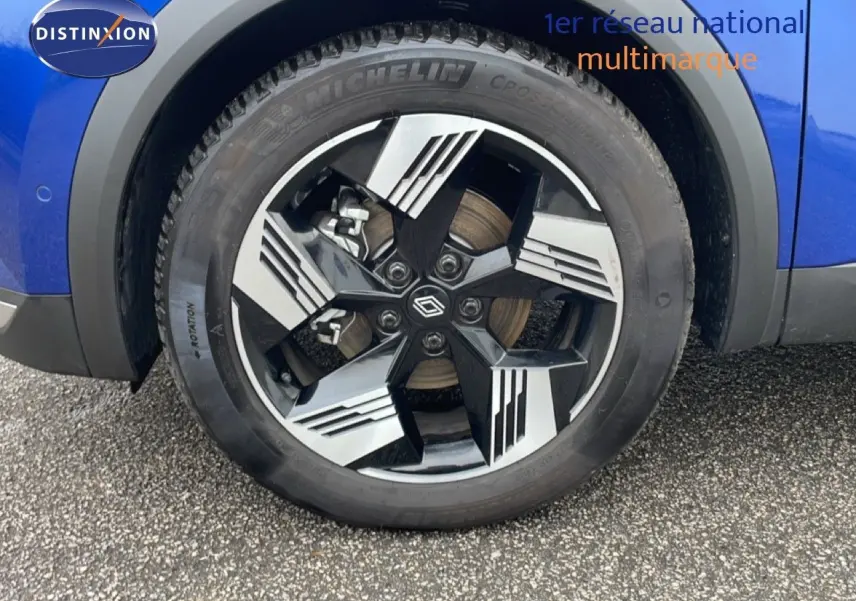 Gros plan sur la roue avant droite du Renault Symbioz 2025 en bleu Iron Metal avec jante alliage noire et argentée.