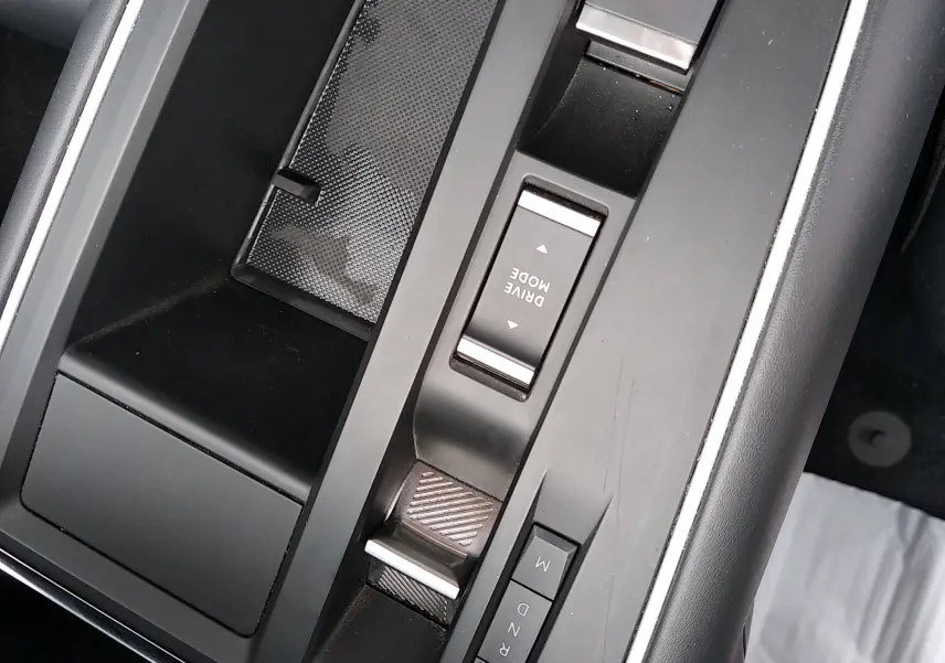 Gros plan sur la console centrale noire du Citroën C5 Aircross 2023 avec commandes électroniques et rangement intégré.