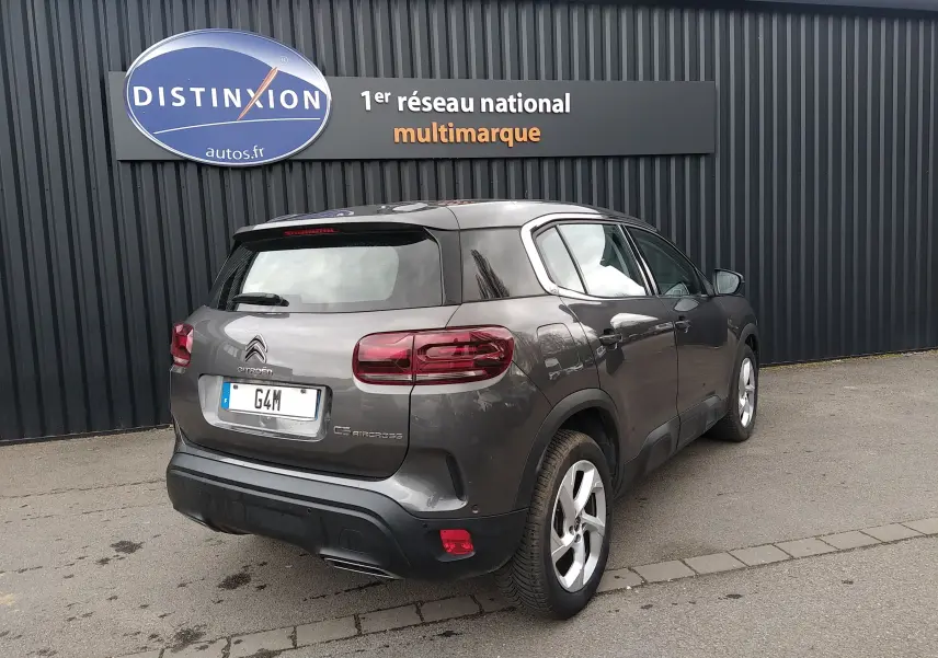 Vue 3/4 arrière droite d'un Citroën C5 Aircross gris platinium avec feux arrière LED et jantes alliage 18 pouces.