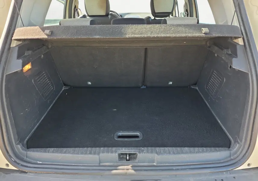 Coffre ouvert vu de l'arrière d'un Renault Captur ivoire 2018, montrant l'espace de chargement et la banquette arrière.