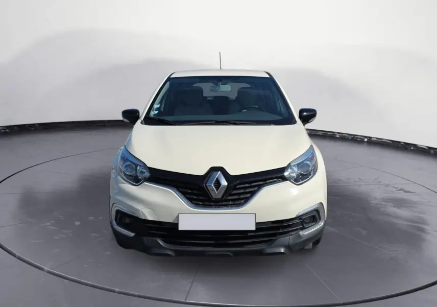 Vue frontale d'un Renault Captur ivoire 2018 avec calandre noire et phares arrondis, sur fond neutre.