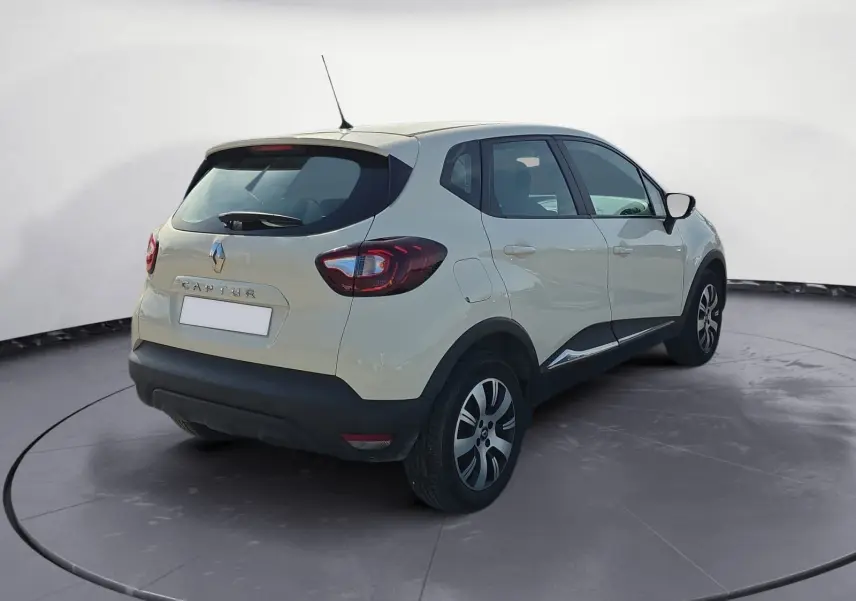 Renault Captur ivoire en 3/4 arrière droit, mettant en valeur ses feux arrière et ses jantes alliage noires.