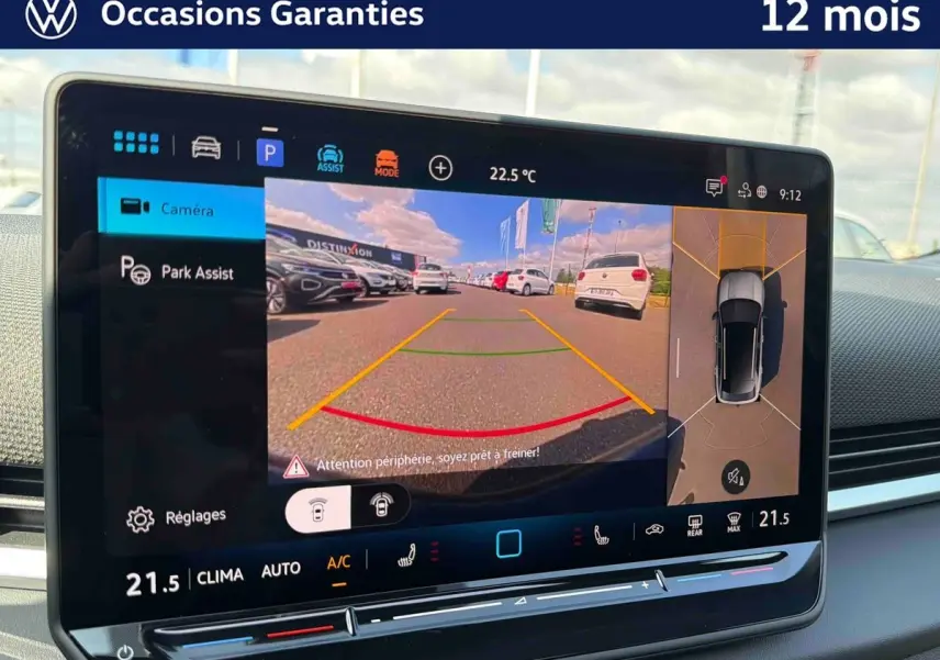 Vue intérieure de l'écran tactile du Volkswagen T-Roc noir montrant l'assistance au stationnement avec caméra et vue périmétrique 360°.